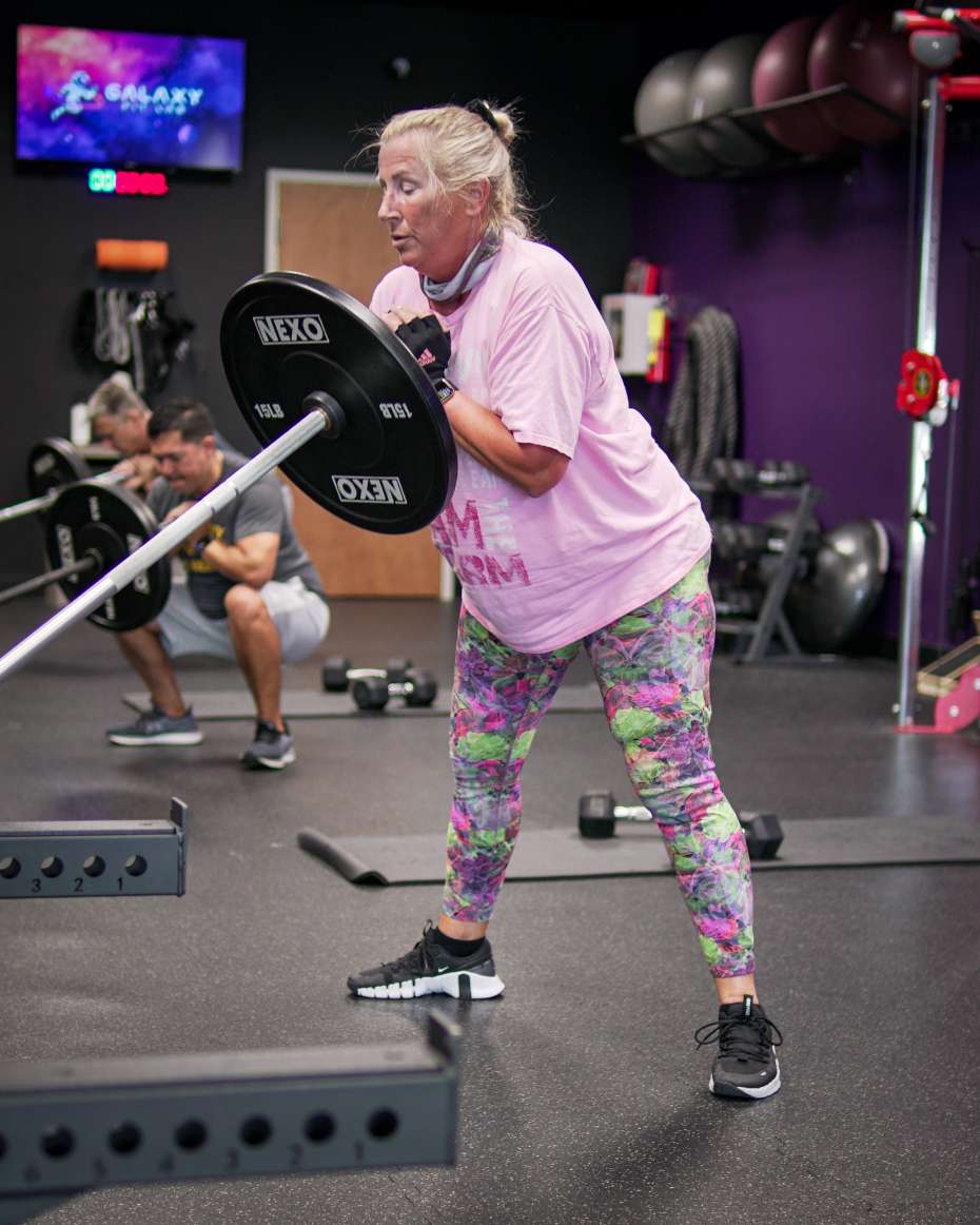 Woman strength training with a coach at Galaxy Fit Lab in Naples, FL